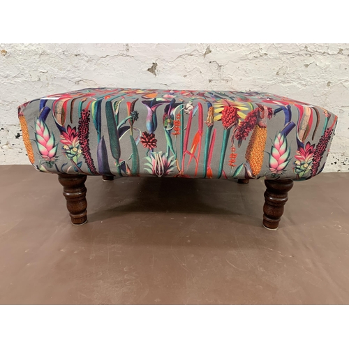 72 - A modern floral fabric upholstered footstool with turned wooden supports - approx. 33cm high 65cm wi... 