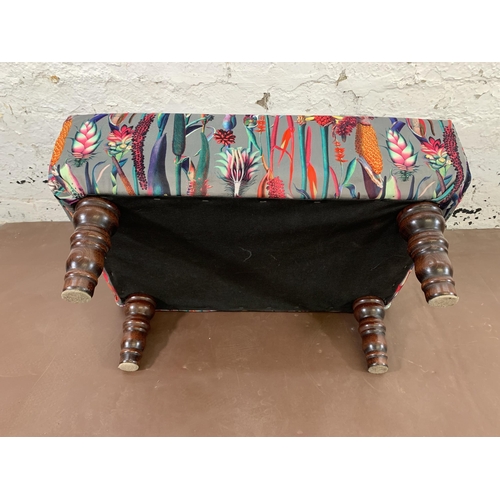 72 - A modern floral fabric upholstered footstool with turned wooden supports - approx. 33cm high 65cm wi... 