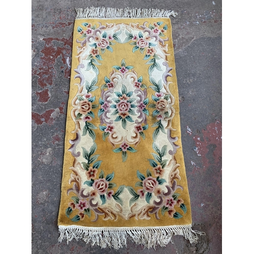 81 - A mid/late 20th century yellow floral pattern rug - approx. 156cm x 79cm