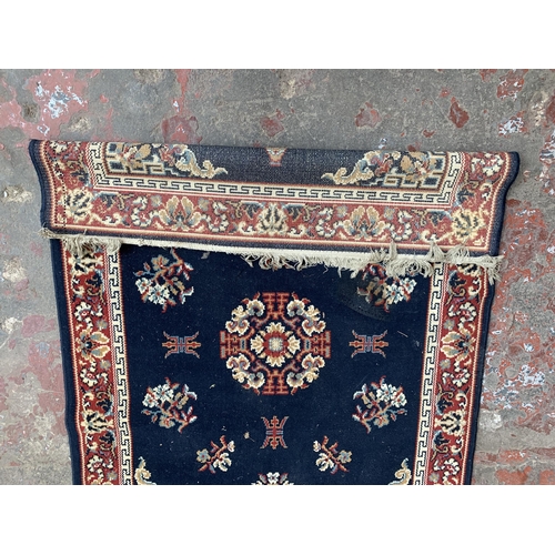 83 - A mid/late 20th century red and blue machine woven rug - approx. 165cm x 119cm