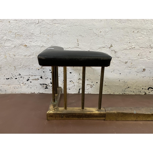 89 - An early 20th century brass and black vinyl upholstered club fender - approx. 43cm high x 142cm wide... 