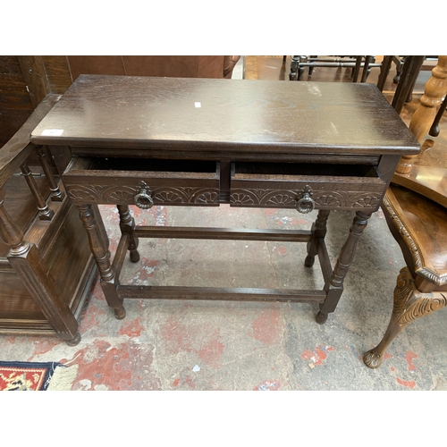 94 - A carved oak two drawer console table - approx. 74cm high x 78cm wide x 32cm deep