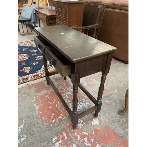 94 - A carved oak two drawer console table - approx. 74cm high x 78cm wide x 32cm deep