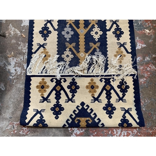 4 - A blue and cream Kilim rug - approx. 155cm x 75cm