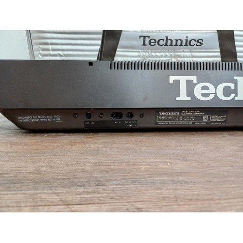 A cased Technics SX-K200 electronic keyboard
