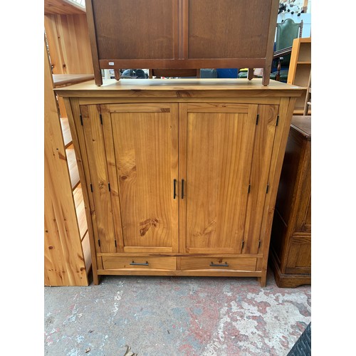 145 - A modern pine two door TV cabinet - approx. 127cm high x 120cm wide x 69cm deep