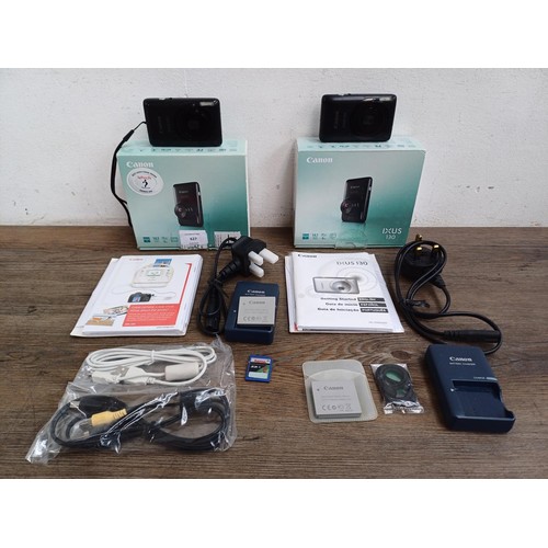 627 - Two boxed Canon IXUS 130 14.1mp compact digital cameras with batteries, chargers, software discs and... 