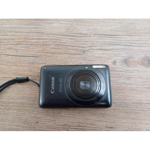 627 - Two boxed Canon IXUS 130 14.1mp compact digital cameras with batteries, chargers, software discs and... 