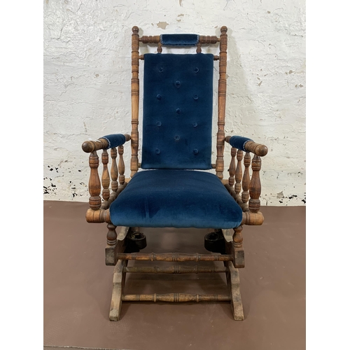 160 - An early 20th century American beech and blue fabric upholstered rocking chair