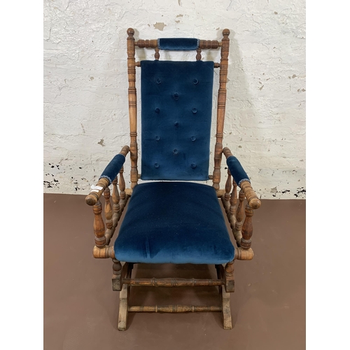 160 - An early 20th century American beech and blue fabric upholstered rocking chair