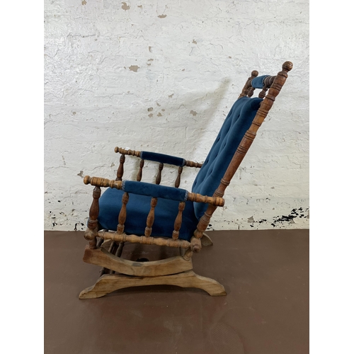 160 - An early 20th century American beech and blue fabric upholstered rocking chair