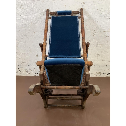 160 - An early 20th century American beech and blue fabric upholstered rocking chair