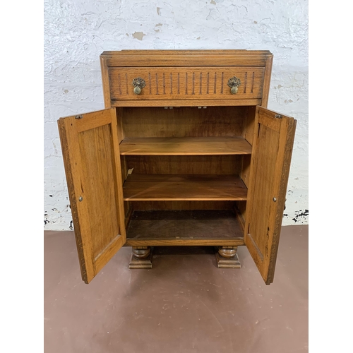 182 - An Art Deco carved oak two door cabinet - approx. 94cm high x 60cm wide x 31cm deep