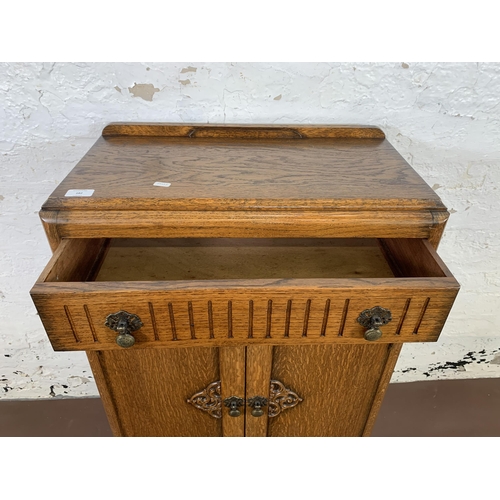 182 - An Art Deco carved oak two door cabinet - approx. 94cm high x 60cm wide x 31cm deep