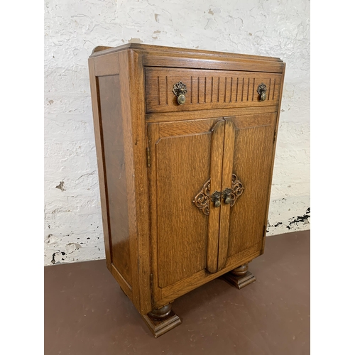 182 - An Art Deco carved oak two door cabinet - approx. 94cm high x 60cm wide x 31cm deep