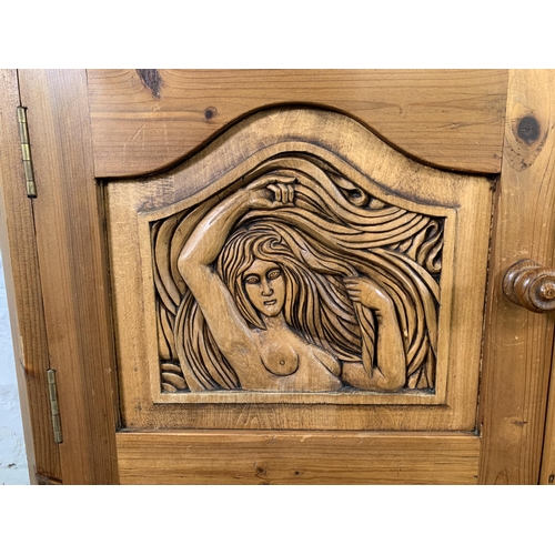 184 - A carved pine two door cabinet - approx. 110cm high x 94cm wide x 40cm deep