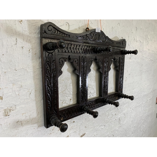 19 - A Victorian Gothic Revival style carved oak wall hanging seven hook coat rack - approx. 44cm high x ... 