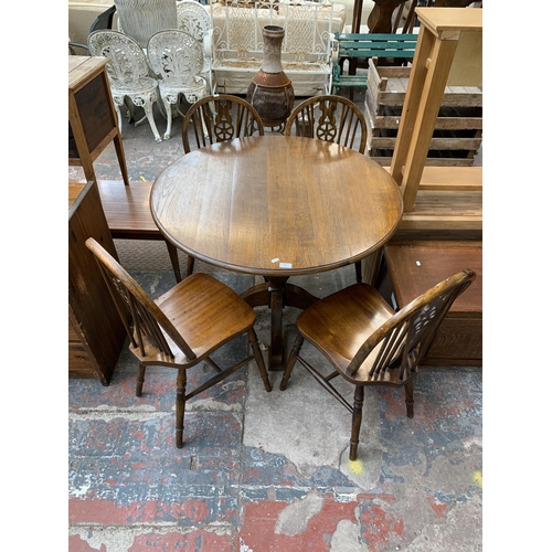 207 - An oak circular pedestal dining table and four beech wheelback dining chairs - table approx. 75cm hi... 