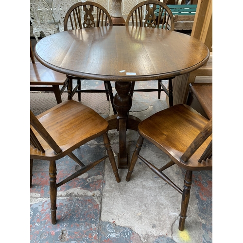 207 - An oak circular pedestal dining table and four beech wheelback dining chairs - table approx. 75cm hi... 