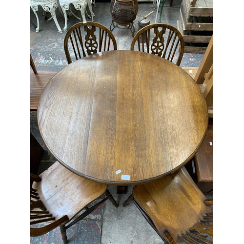 207 - An oak circular pedestal dining table and four beech wheelback dining chairs - table approx. 75cm hi... 