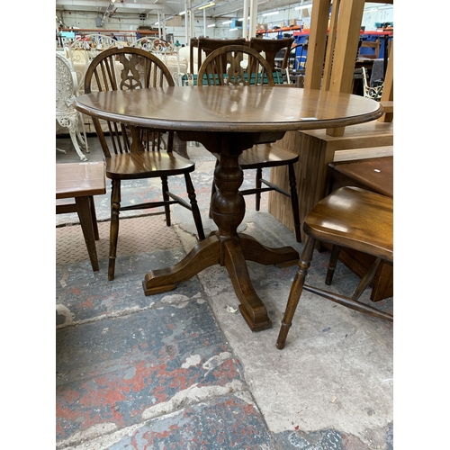 207 - An oak circular pedestal dining table and four beech wheelback dining chairs - table approx. 75cm hi... 