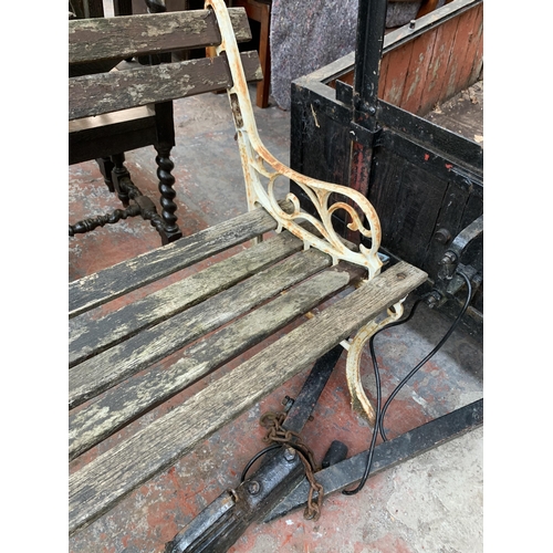 235 - A Victorian style cast metal and wooden slatted two seater garden bench - approx. 122cm wide