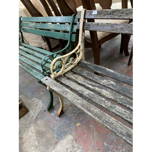 235 - A Victorian style cast metal and wooden slatted two seater garden bench - approx. 122cm wide