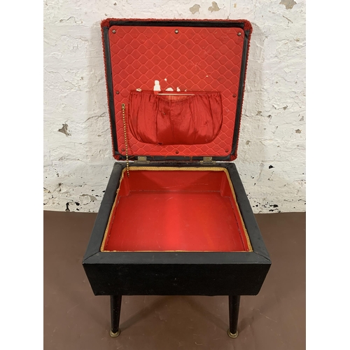 31 - A mid 20th century black vinyl and red fabric upholstered sewing stool on atomic supports - approx. ... 