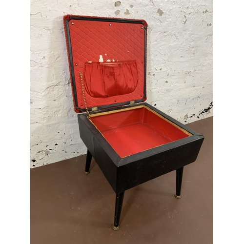 31 - A mid 20th century black vinyl and red fabric upholstered sewing stool on atomic supports - approx. ... 