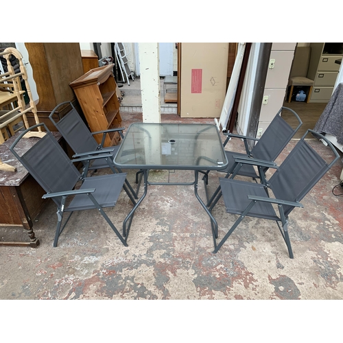 43 - A grey metal five piece patio set comprising four folding chairs and glass topped table - approx. 72... 