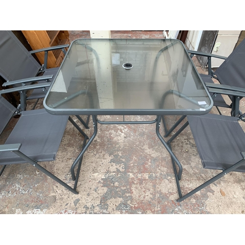 43 - A grey metal five piece patio set comprising four folding chairs and glass topped table - approx. 72... 