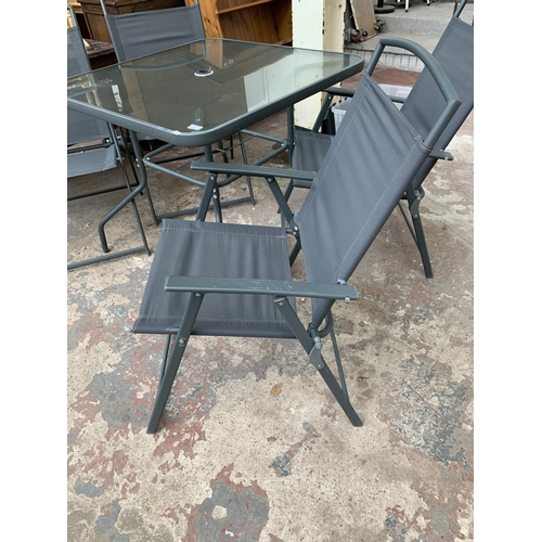 43 - A grey metal five piece patio set comprising four folding chairs and glass topped table - approx. 72... 