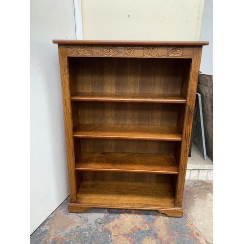 48 - A carved oak bookcase - approx. 112cm high x 80cm wide x 30cm deep