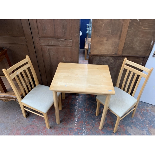 49 - A modern beech rectangular dining table and two chairs - approx. 75cm high x 60cm wide x 74cm long