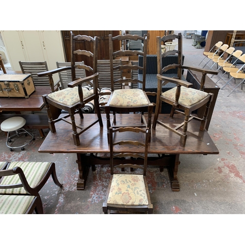 64 - An oak rectangular trestle dining table and six beech ladder back chairs - table approx. 83cm high x... 