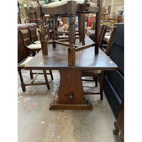 64 - An oak rectangular trestle dining table and six beech ladder back chairs - table approx. 83cm high x... 