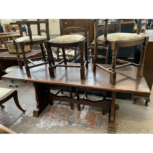 64 - An oak rectangular trestle dining table and six beech ladder back chairs - table approx. 83cm high x... 