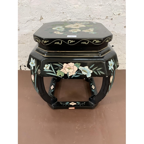 66 - A Chinese hand painted and black lacquered octagonal side table with floral design - approx. 46cm hi... 