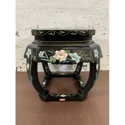 66 - A Chinese hand painted and black lacquered octagonal side table with floral design - approx. 46cm hi... 