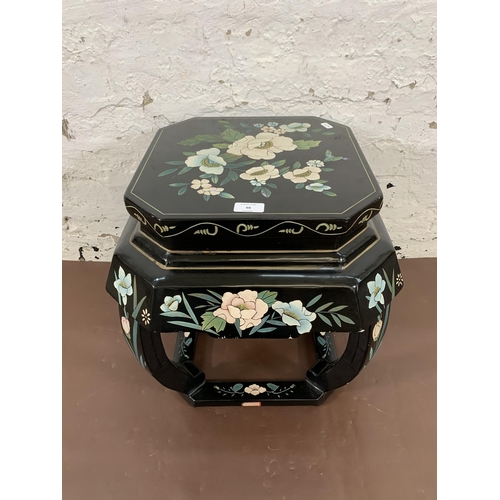 66 - A Chinese hand painted and black lacquered octagonal side table with floral design - approx. 46cm hi... 