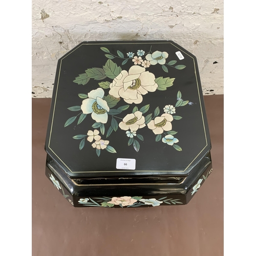 66 - A Chinese hand painted and black lacquered octagonal side table with floral design - approx. 46cm hi... 