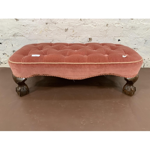 69 - A Georgian style pink fabric upholstered footstool on ball and claw supports