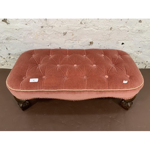 69 - A Georgian style pink fabric upholstered footstool on ball and claw supports