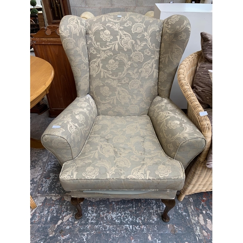 74 - A Victorian style floral fabric upholstered wingback armchair on cabriole supports