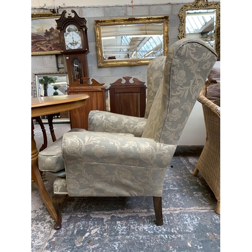 74 - A Victorian style floral fabric upholstered wingback armchair on cabriole supports