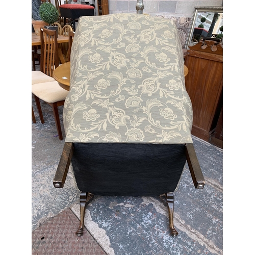 74 - A Victorian style floral fabric upholstered wingback armchair on cabriole supports