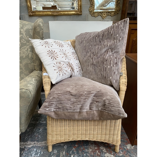 75 - A wicker and cane armchair with cushions