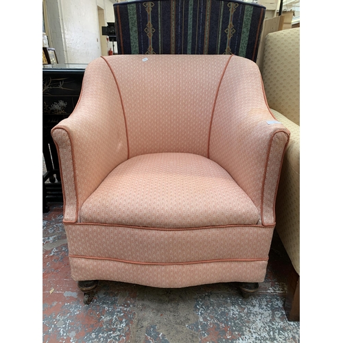 79 - A late 19th/early 20th century fabric upholstered armchair on turned wooden supports and castors