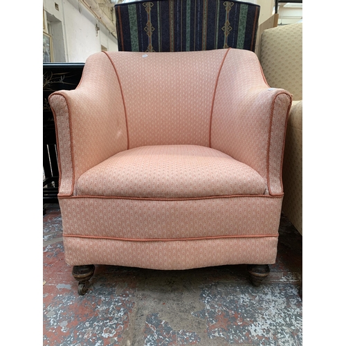 79 - A late 19th/early 20th century fabric upholstered armchair on turned wooden supports and castors