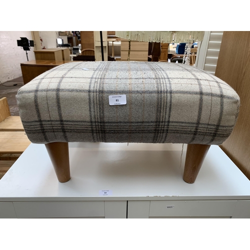 81 - A modern tartan fabric upholstered footstool on turned beech supports